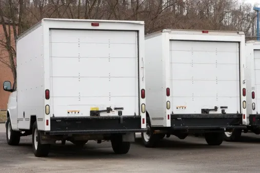 Two Moving Trucks Parked seen from Behind